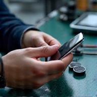 Technician inspecting a phone, illustrating diagnosis